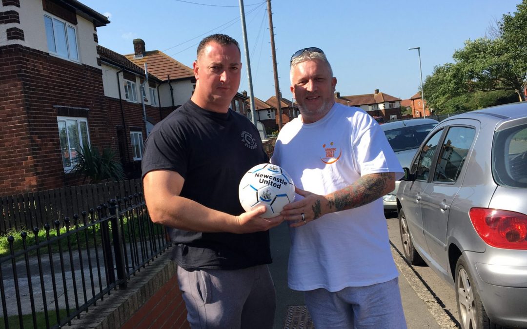 HARTLEPOOL STRONGMAN JOHNNY CROSSLING DONATES SIGNED FOOTBALL TO CHARITY.
